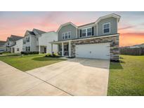 Two-story home features a stone facade, a two-car garage, and a well-maintained lawn at 705 Squire Pope Rd, Summerville, SC 29486