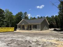 Charming single-story home with a covered front porch, gray siding, and black shutters nestled among green trees at 729 Burlington Rd, Walterboro, SC 29488