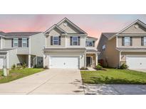 Charming two-story home featuring a two-car garage, inviting entrance and well-manicured lawn at 743 Redbud Ln, Summerville, SC 29486