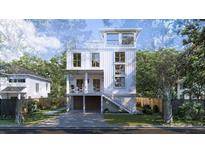 Beautiful three-story home with a charming staircase and a well-manicured lawn at 814 Palm Blvd, Isle of Palms, SC 29451