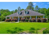 Inviting single-story home with a wide porch, lush lawn, and colorful shrubs at 101 Firestone Ct, Summerville, SC 29483