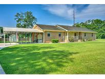Charming single story brick home with covered parking and a well-manicured lawn in a suburban neighborhood at 101 Parkside Dr, Goose Creek, SC 29445