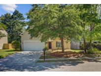 Charming two-story home with a well-manicured lawn, complemented by mature trees and a two car garage at 105 Moon Shadow Ln, Summerville, SC 29485