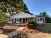 Charming single-story home featuring a well-manicured lawn and inviting front porch at 121 Camelot Dr, Goose Creek, SC 29445