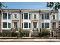 Charming brick townhomes feature bay windows, white shutters, black iron fencing, and manicured landscaping at 122 Beaufain St # C, Charleston, SC 29401