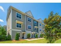 Stylish townhome exterior showing modern architecture, tidy landscaping, and a clear blue sky at 1242 Allusion Ln # 206, Mount Pleasant, SC 29466