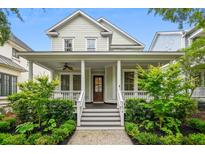 Charming two-story home featuring a welcoming front porch with elegant columns and beautifully landscaped yard at 1474 Blue Cascade Dr, Mount Pleasant, SC 29464