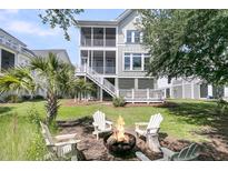Relaxing backyard features a fire pit, Adirondack chairs, and a spacious lawn at 2072 Amenity Park Dr, Mount Pleasant, SC 29466