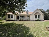 Charming one-story home with a light yellow exterior, a copper-colored metal roof and a well-manicured front lawn at 2173 Annie Laura Ln, Mount Pleasant, SC 29466