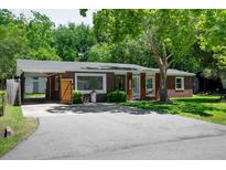 Charming brick home featuring a carport, mature trees, and a well-manicured lawn at 2515 Violet Ave, North Charleston, SC 29405