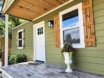 Charming front porch with a white door, wood shutters, and a decorative flower pot adds curb appeal at 2963 Alabama Dr, North Charleston, SC 29405
