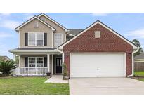 Charming two-story home featuring a brick accent garage and inviting front porch at 301 Edenton Rd, Goose Creek, SC 29445