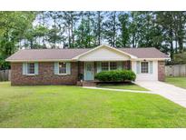 Charming brick home with well-maintained lawn, light blue shutters, and mature trees at 305 Forest Cir, Summerville, SC 29483