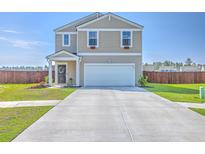 Two-story home featuring a two-car garage, well-maintained lawn, and charming curb appeal on a bright day at 307 Fox Gap Rd, Summerville, SC 29486