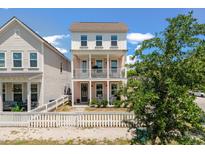 Charming two-story pink home with a white picket fence and double balconies, perfect for enjoying the outdoors at 4631 Scout Aly, North Charleston, SC 29405
