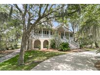 Stunning two-story home with mature trees and a wrap-around porch and elegant stairway entry at 4702 Blockhouse Ln, Hollywood, SC 29449