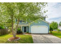 Charming two-story home with a well-manicured lawn, attached garage, and beautiful landscaping at 489 Dolphin Dr, Summerville, SC 29485