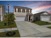 Charming two-story home with a well-manicured lawn and a two-car garage and inviting entrance at 5003 Ferry Field Dr, Summerville, SC 29485