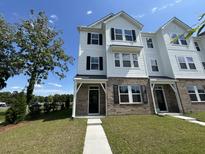 Charming two-story townhome featuring brick accents, black shutters, and a well-manicured lawn at 5100 Double Eagle, Summerville, SC 29485