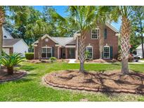 Charming brick home with a well-manicured lawn and mature palm trees in a desirable neighborhood at 569 Pointe Of Oaks Rd, Summerville, SC 29485