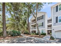 Charming gray multi-story condo building with balconies and lush landscaping in a desirable neighborhood at 60 Fenwick Hall Aly # 415, Johns Island, SC 29455