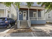 Charming two-story home with blue siding, a cozy front porch, and inviting brick steps at 634 Rutledge Ave, Charleston, SC 29403