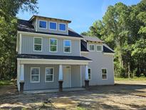 Charming two-story home featuring a covered front porch and light gray siding at 6343 N Hwy 17, Awendaw, SC 29429