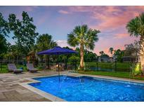 Beautiful in-ground pool with water features and fire pit on a fenced lot with lounge chairs at 6910 Tanner Hall Blvd, Hanahan, SC 29410