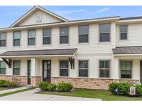 Charming townhome with white siding, stone accents, and a covered entryway, creating curb appeal at 7812 Park Gate Dr, North Charleston, SC 29418