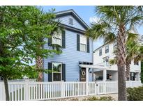 Charming two-story blue home with white picket fence and mature palm trees, creating a welcoming curb appeal at 8604 Bowen Corner Ave, Hanahan, SC 29410