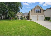 Charming two-story home with a well-manicured lawn and a two car garage at 105 Corral Cir, Summerville, SC 29485