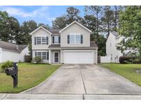 Charming two-story home with blue shutters, well-maintained lawn, and large driveway at 125 Towering Pine Dr, Ladson, SC 29456