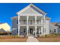 Charming two-story home featuring a double front porch with rocking chairs and swing at 128 Sandy Bend Ln, Summerville, SC 29486