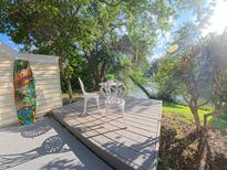 View of a deck with white chairs overlooking the water surrounded by greenery at 15 Town Park Ln # A, Charleston, SC 29412