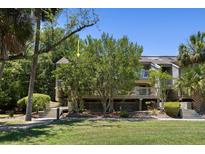 Inviting exterior featuring a multi-level deck and lush landscaping, creating a serene outdoor space at 1634 Live Oak Park, Seabrook Island, SC 29455