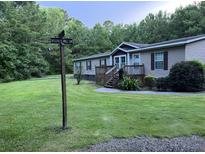 Well-maintained single Gathering home with a green lawn and wooden front porch, plus a street sign at 1671 Dawson Branch Rd, Summerville, SC 29483