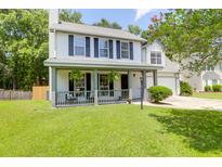 Charming two-story home featuring a covered front porch and well-maintained landscaping at 1703 Dotterers Run, Charleston, SC 29414