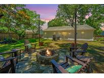 Inviting backyard with a stone fire pit and Adirondack chairs, perfect for outdoor entertaining at 2016 Wild Flower Ln, Charleston, SC 29414