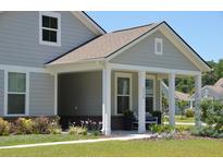 Charming covered front porch featuring white columns and landscaped front yard at 2020 Parish House Cir, Johns Island, SC 29455