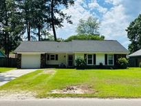 Charming one-story home with a well-maintained lawn and mature trees at 214 Four Iron Dr, Summerville, SC 29483