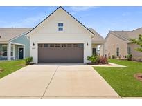 Charming home featuring a two-car garage, neutral siding, and meticulously manicured landscaping at 220 Garden Gate Way, Summerville, SC 29486
