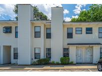 Inviting townhouse with light yellow siding, complemented by lush green bushes and ample parking at 235 Pine Shadow Dr, Goose Creek, SC 29445