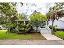 Charming two-story home with a front porch, lush landscaping, and a welcoming entrance at 2613 Rivertowne Pkwy, Mount Pleasant, SC 29466