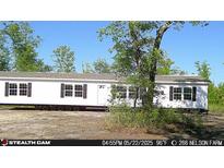 A charming single-story white home featuring black shutters and a well-maintained yard, perfect for comfortable living at 266 Nelson Farm Ln, Cross, SC 29436