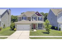 Charming two-story home with a well-manicured lawn, two-car garage, and inviting red front door at 308 Legendres Dr, Goose Creek, SC 29445