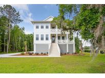 Charming two-story home featuring double front porches, white siding, and manicured landscaping at 3143 Vanessa Lynne Ln, Johns Island, SC 29455
