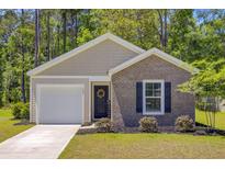 Charming single-story home with brick accents, a well-manicured lawn, and an inviting entrance at 407 Spruce Ivy St, Moncks Corner, SC 29461