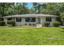 Charming single-story home featuring a well-manicured lawn and a classic brick facade at 408 N Palmetto St, Summerville, SC 29483