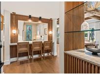 Bright kitchen boasts a breakfast bar with stylish pendant lighting and wood slat accent wall at 4943 Green Dolphin Way, Kiawah Island, SC 29455