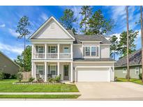 Charming two-story home featuring a welcoming front porch, two car garage, and beautiful landscaping at 523 Kilarney Rd, Summerville, SC 29483
